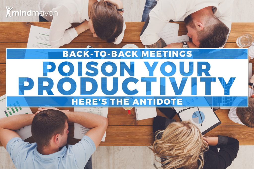 Professionals with their heads on a table conveying the impact of back-to-back meetings.